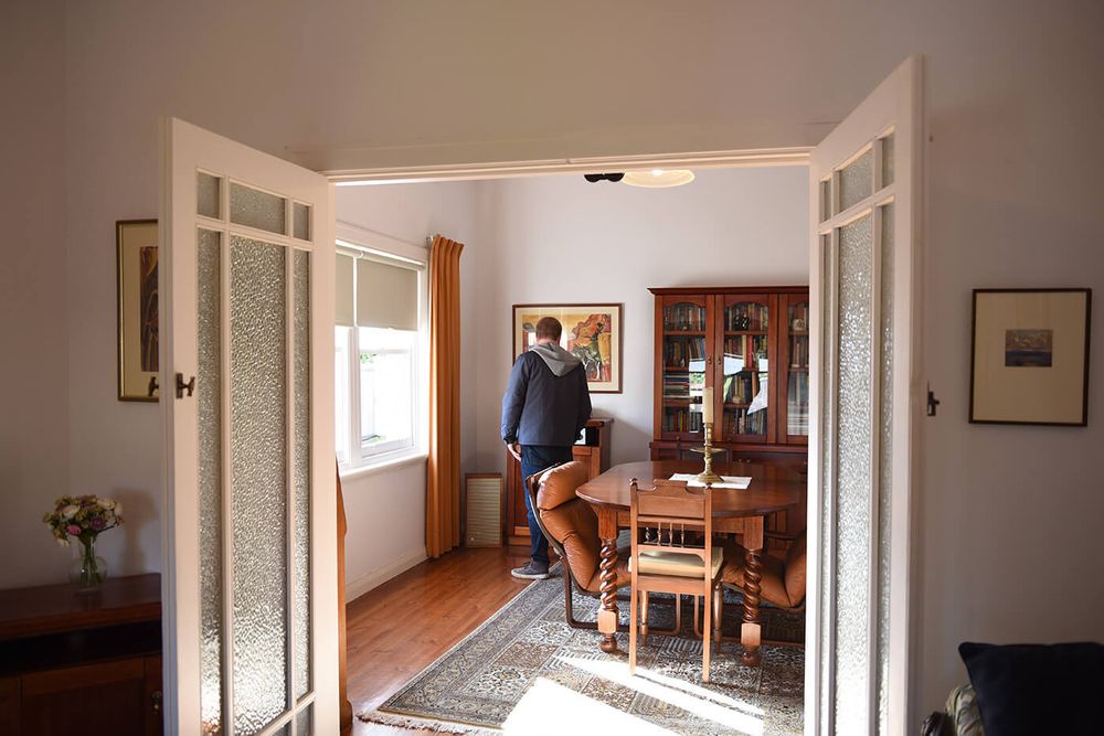 A person looks at a painting in a house.