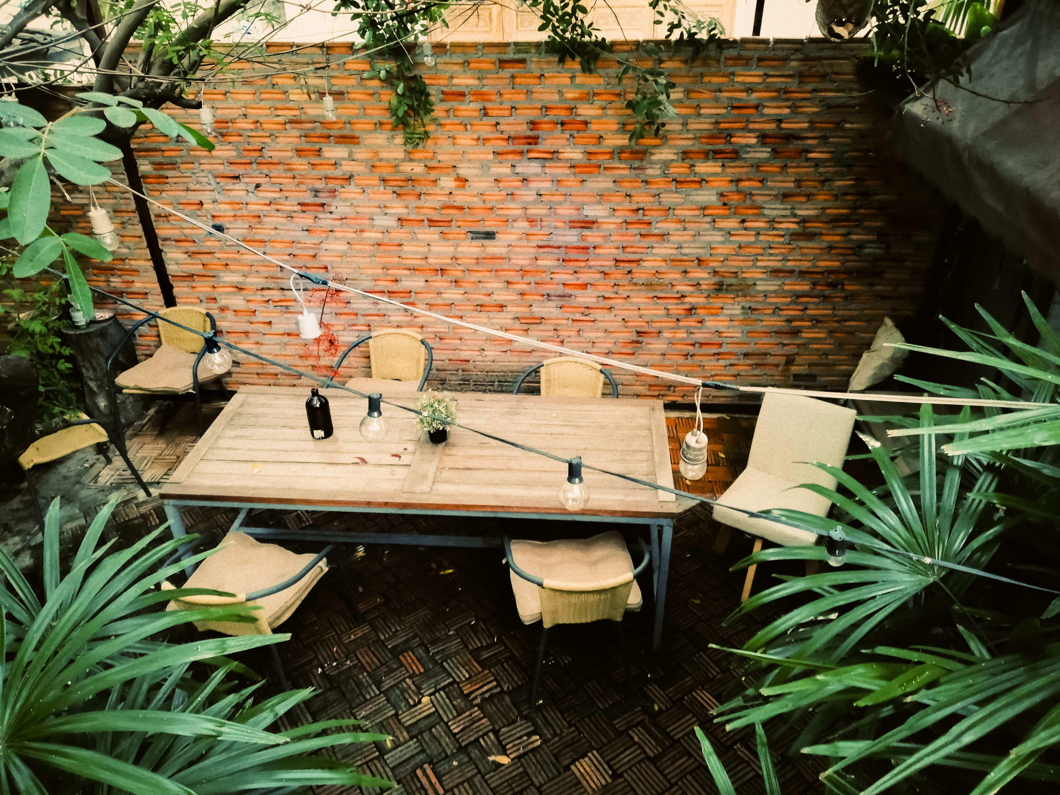 Outdoor table in courtyard with brick wall