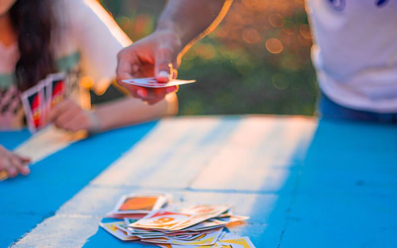 People playing uno outside on blue table