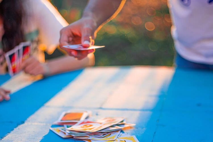 People playing uno outside on blue table