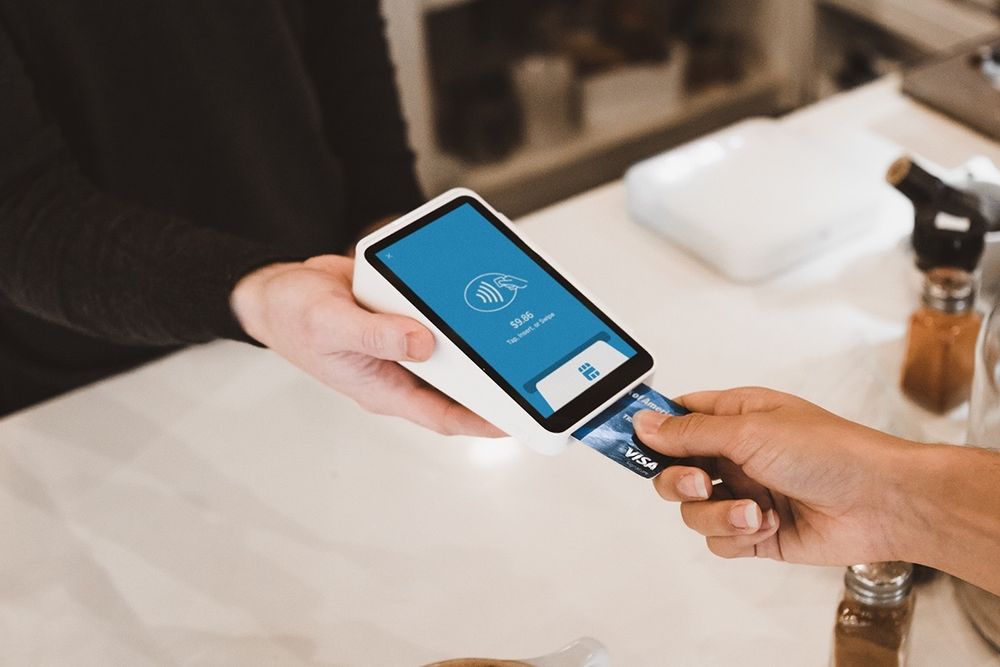 hand using credit card on credit card machine