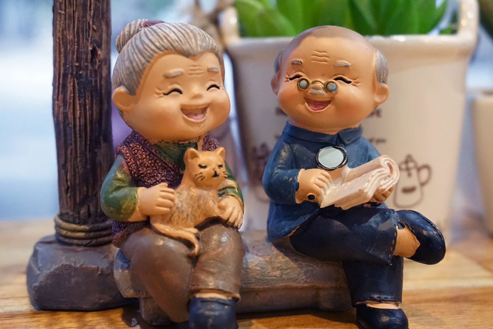 Figurines of an old woman holding a cat and an old man reading a book. It's so cute!