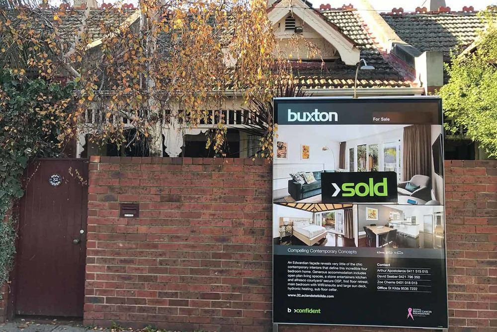 house with sold sign out front