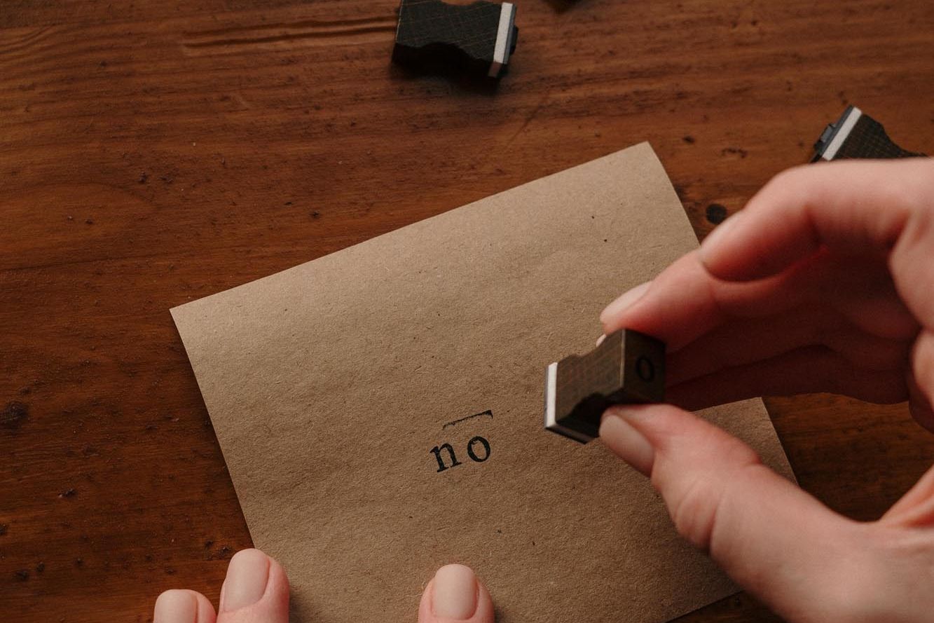 Stamp on a brown piece of paper with the word 'no'. 