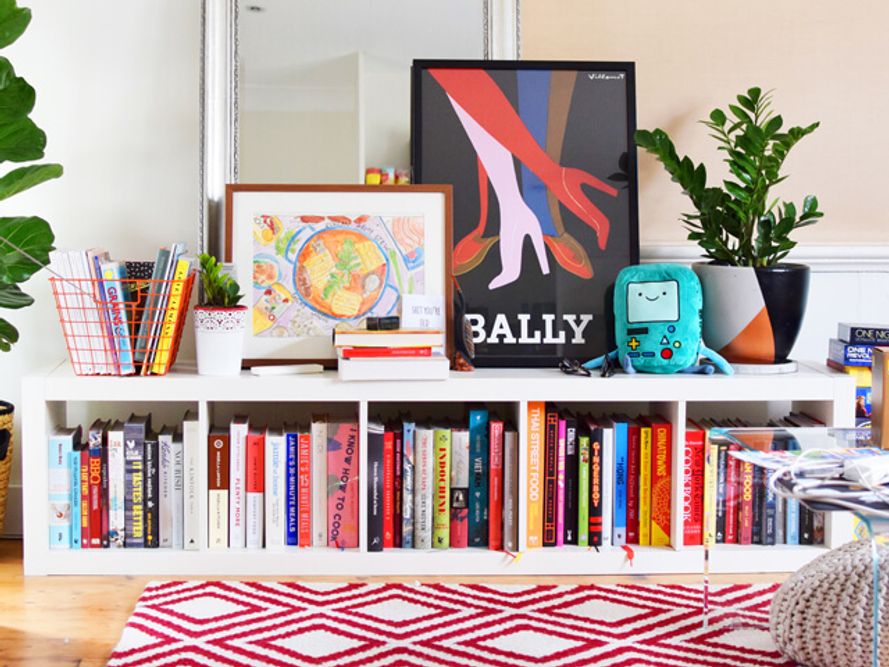 Books and colourful prints on sideboard in living room