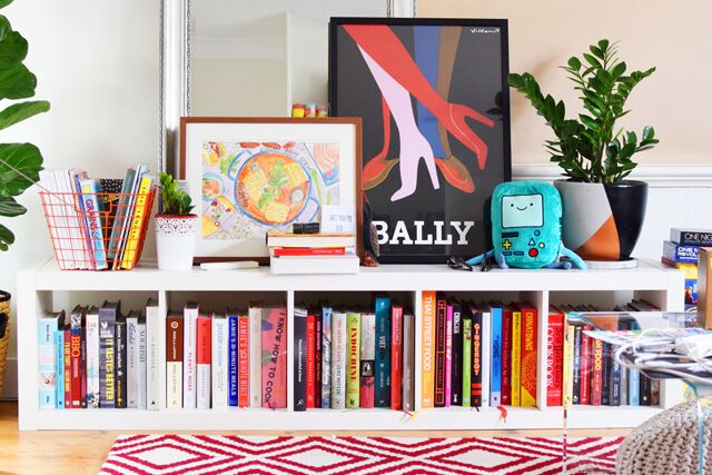 Books and colourful prints on sideboard in living room