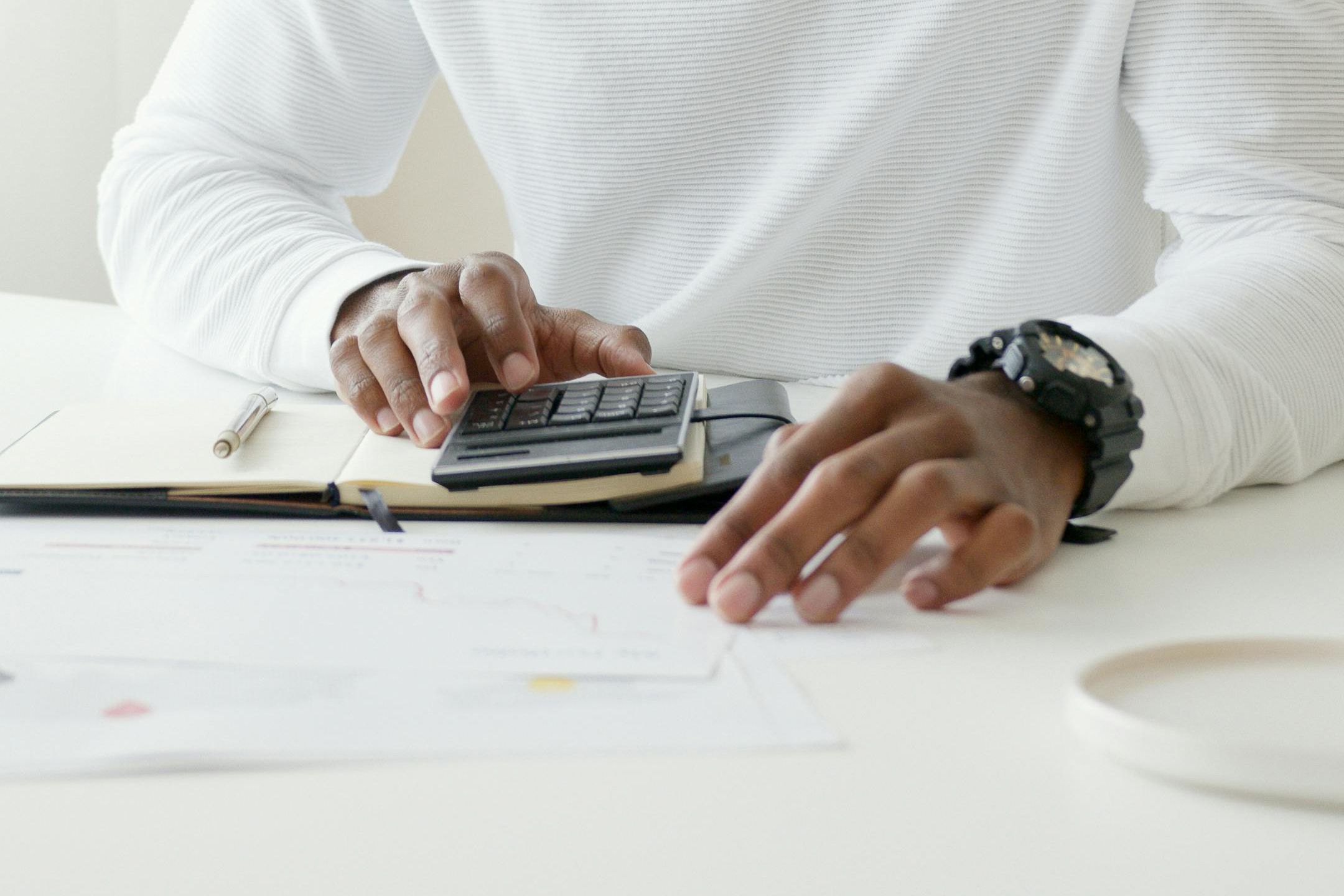 Cropped image of hands working with a notebook and a calculator.