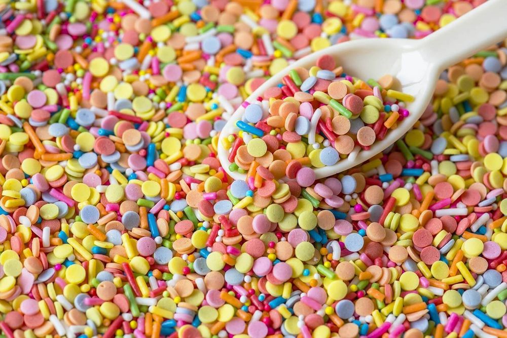 Spoon collecting a large colourful scoop of candy.