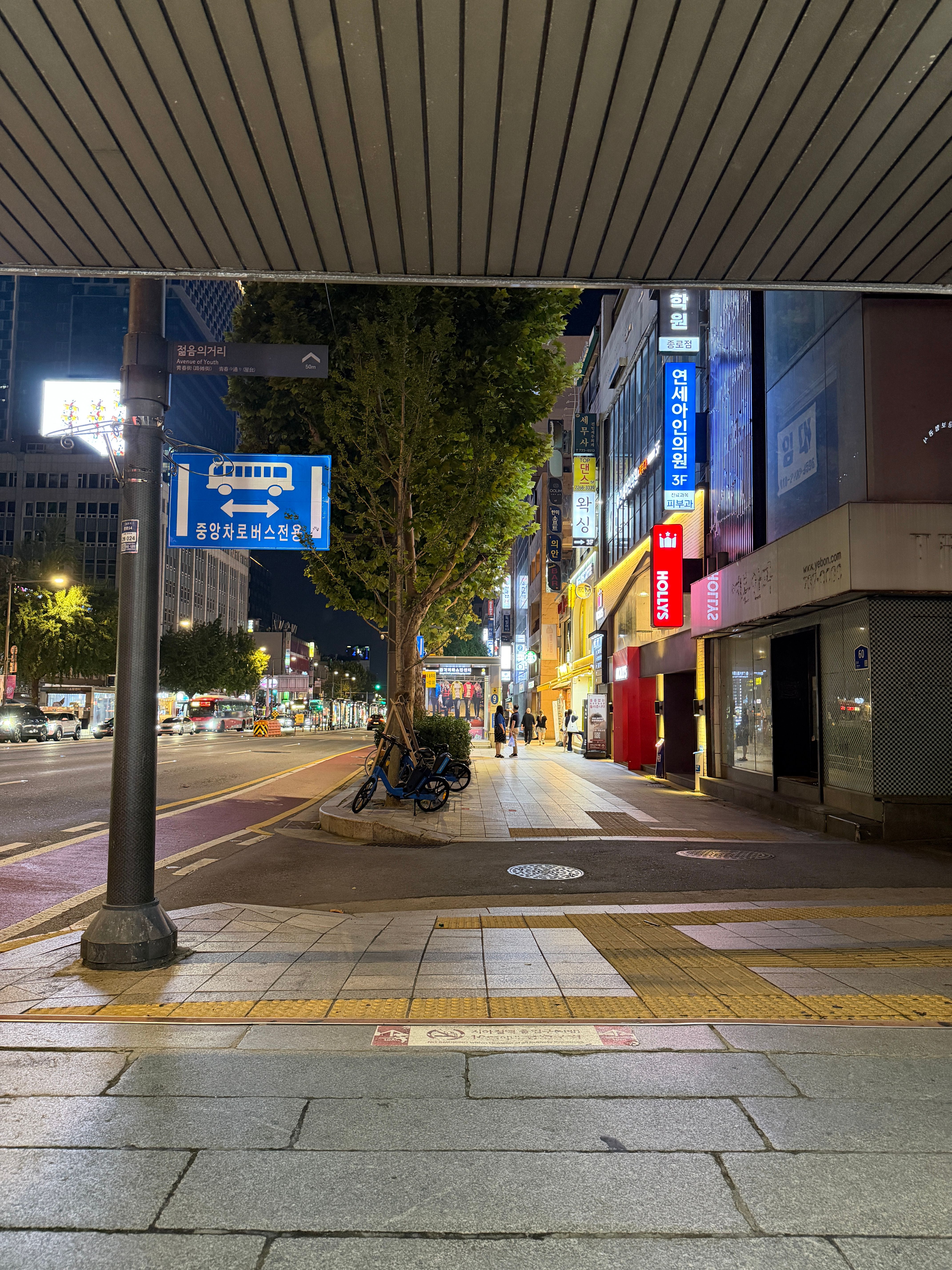 종로 지하철 출구 근처의 밤거리, 버스 전용차로와 상점 간판들