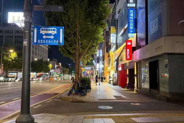 종로 지하철 출구 근처의 밤거리, 버스 전용차로와 상점 간판들