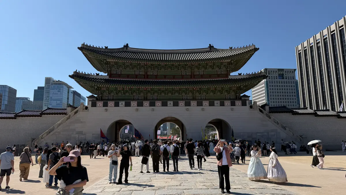 Visitors at Gwanghwamun Gate, the main entrance to Gyeongbokgung Palace, on a clear day