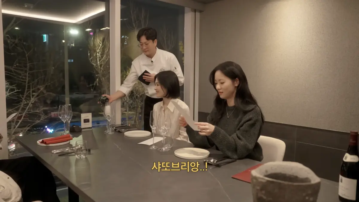 KUT SEOUL 프라이빗 한우 오마카세 카운터에서 메뉴를 읽는 두 손님에게 샴페인을 따르는 소믈리에