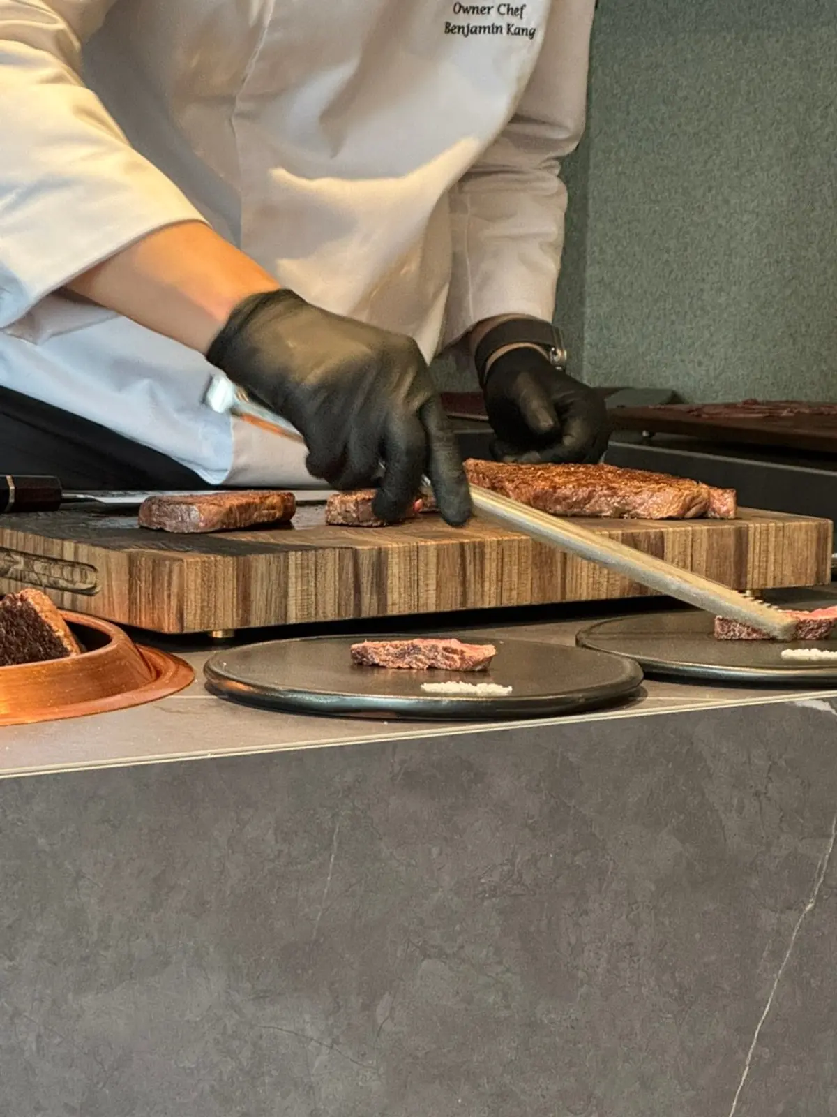 A chef cutting grilled Hanwoo at the guest's seat