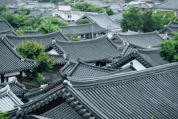옅은 안개에 싸인 푸른 언덕을 배경으로 층층이 펼쳐진, 전주 전통 한옥마을의 곡선미가 살아 있는 기와지붕
