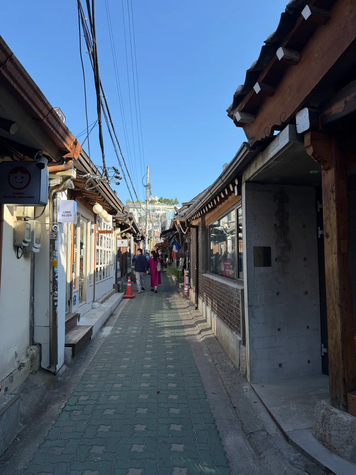 澄んだ空の下、両側に瓦屋根が連なる益善洞の静かな路地