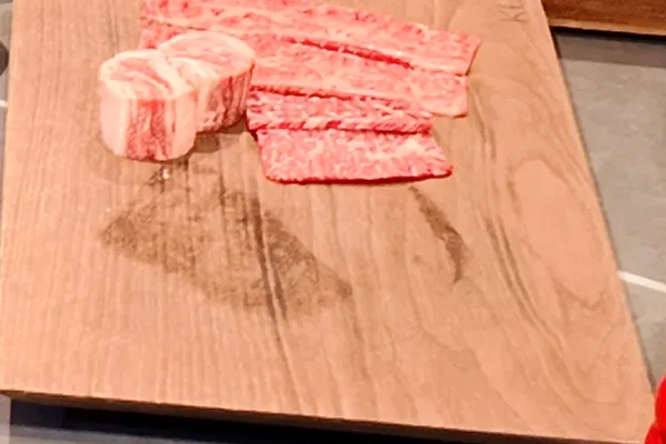 종로 KUT SEOUL의 나무 도마 위에 놓인, 섬세한 마블링을 보이는 4주 웻 에이징 BMS no.9 한우 슬라이스