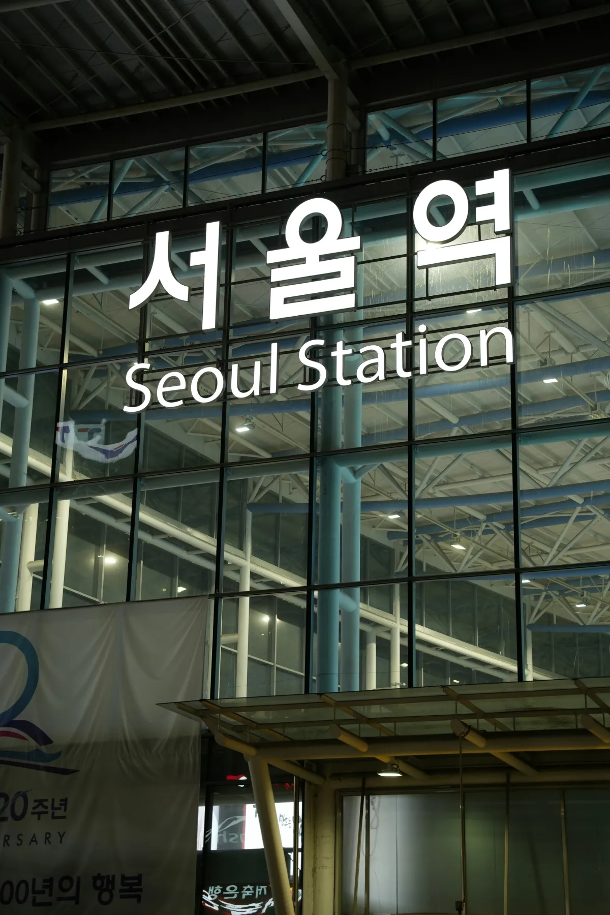 해질 무렵 KTX 터미널 유리 외벽에 한글과 영어로 빛나는 서울역 사인