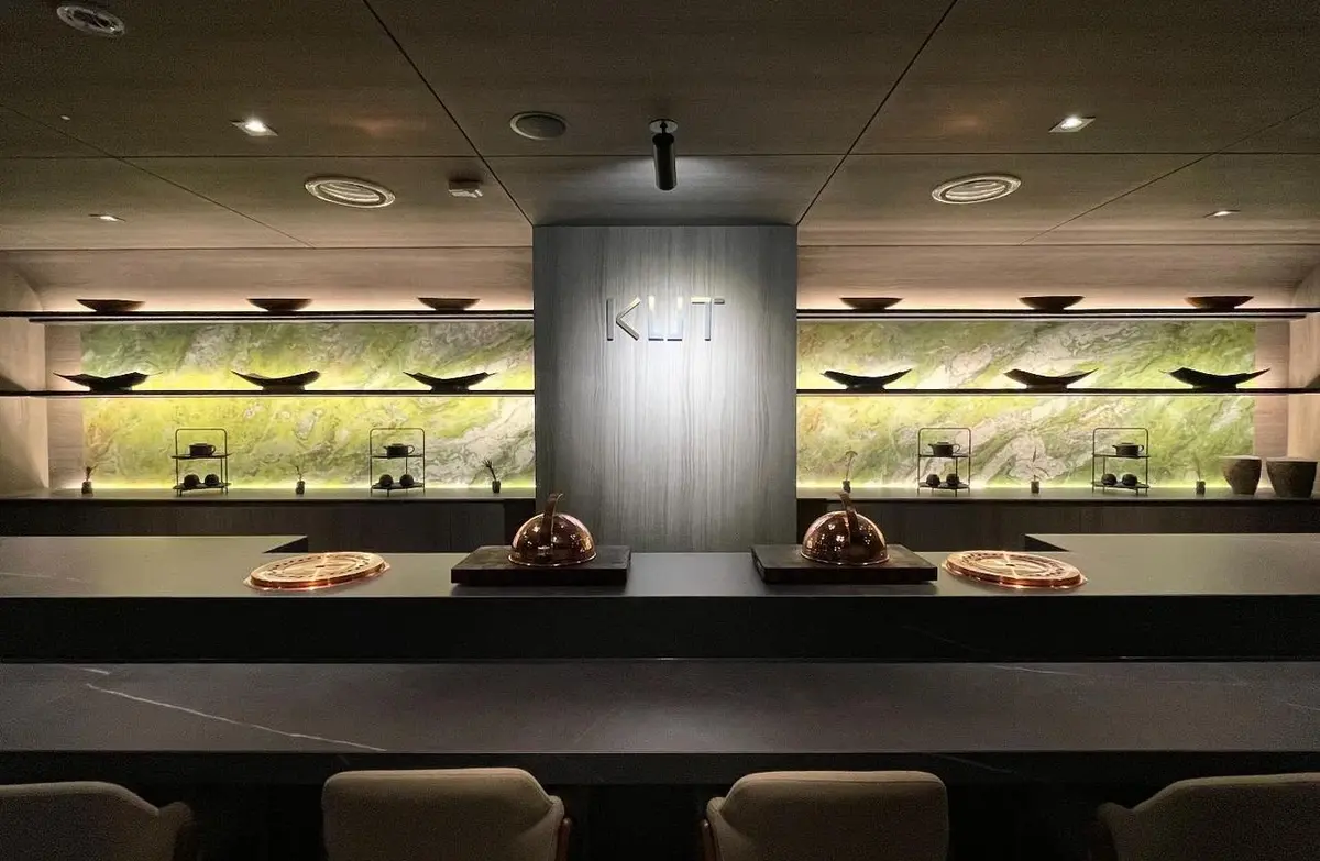 구릿빛 돔과 백라이트가 비치는 옥석 벽, 그리고 KUT 사인이 은은히 빛나는 KUT SEOUL 오마카세 카운터