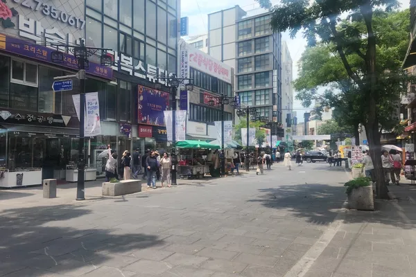 한낮의 햇살 아래 한복 스튜디오, 공예품 가게, 여름 산책객들로 늘어선 종로 인사동길 보행자 거리