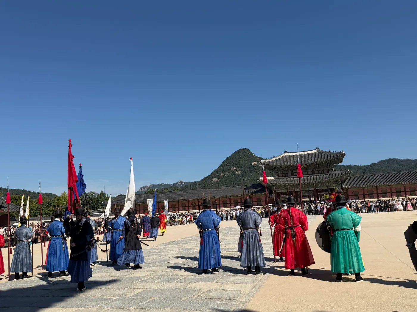 Royal guards in traditional dress at Gyeongbokgung Palace with Bugaksan mountain behind