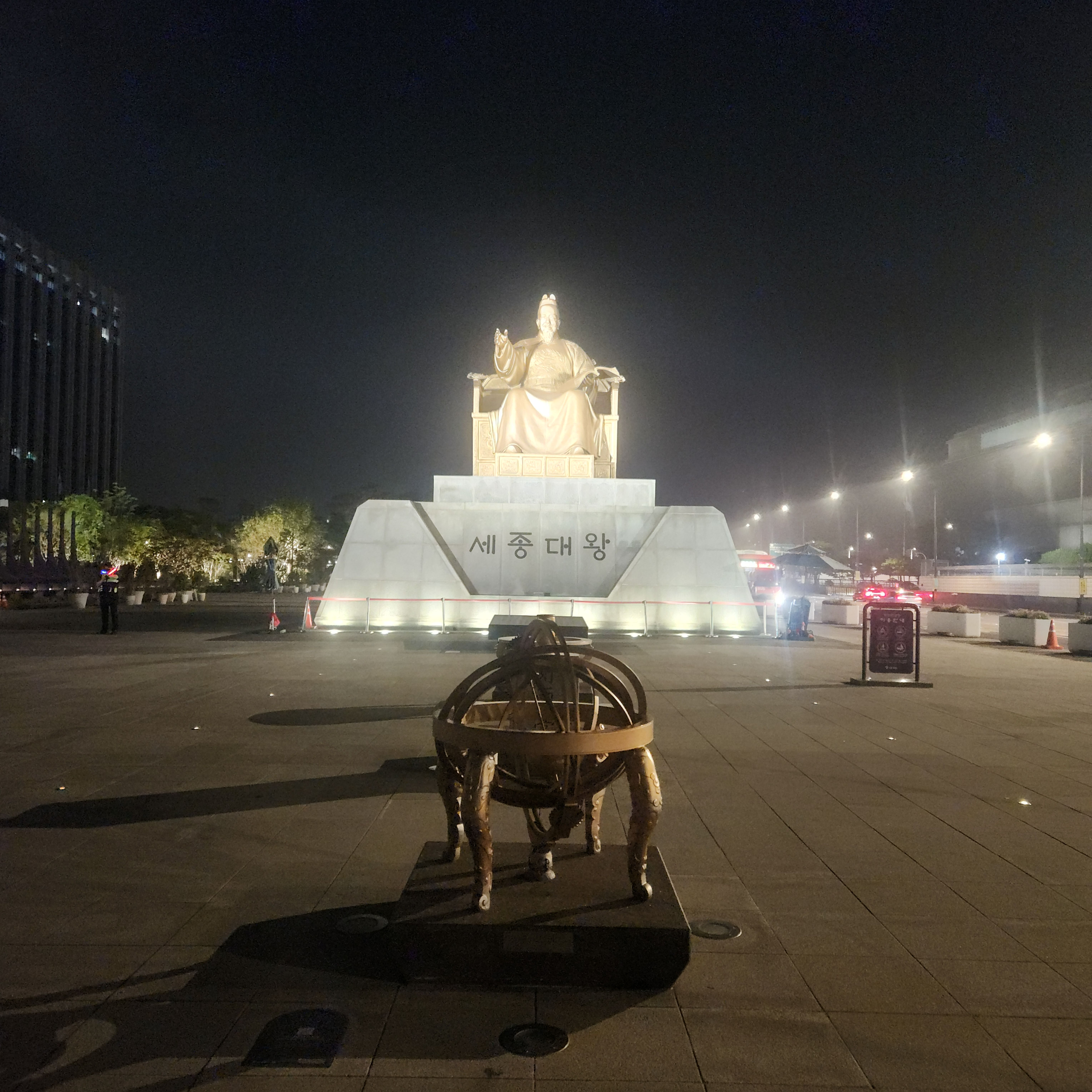 Illuminated bronze statue of King Sejong the Great and armillary sphere at Gwanghwamun Square at night