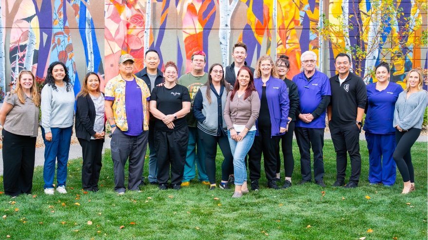 The Renown Crisis Care Team poses for a group photo in front of the Interfaith Mural at Renown Regional Medical Center.