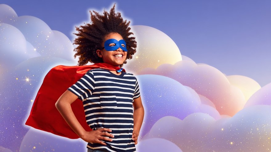 Studio Portrait Of Boy Dressed As Comic Book Superhero Against Magical Background