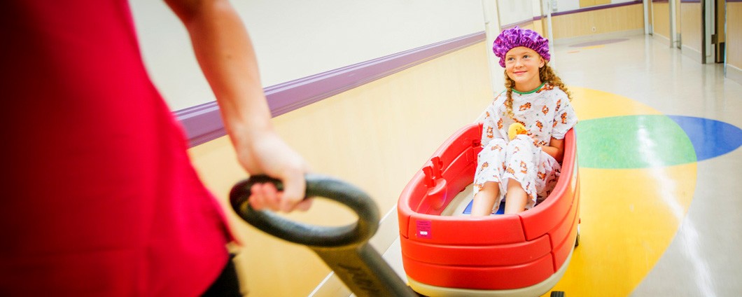 Child life specialist pulling little patient in wagon at Renown Children's Hospital