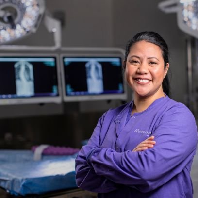 Renown Health employee stands smiling in scrubs