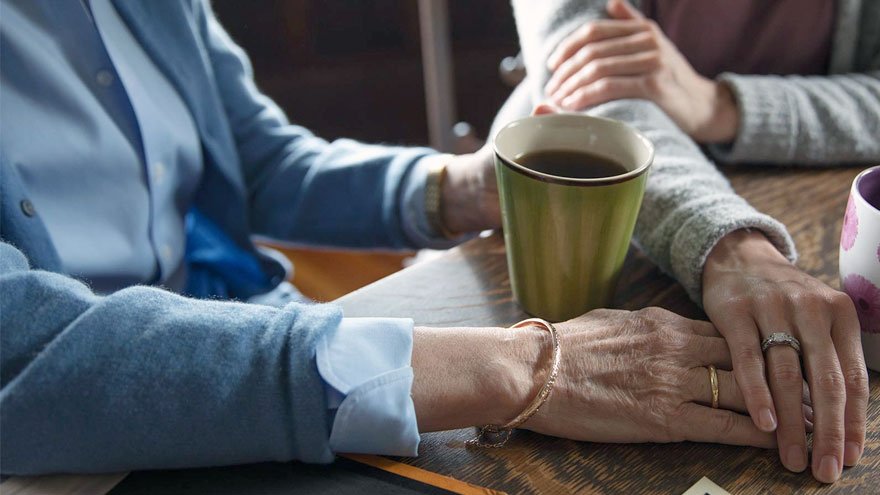 Alzheimer's patient being comforted by friend