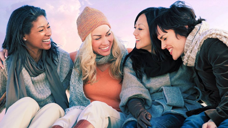 Group of women huddled together laughing