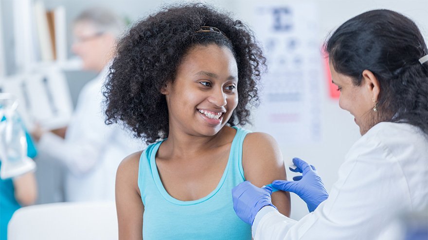 Pharmacist giving teenage girl bandaid 
