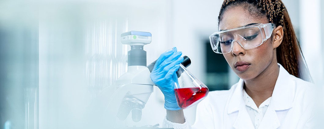 A female scientist conducting an experiment while collecting research data reports in a chemistry laboratory.