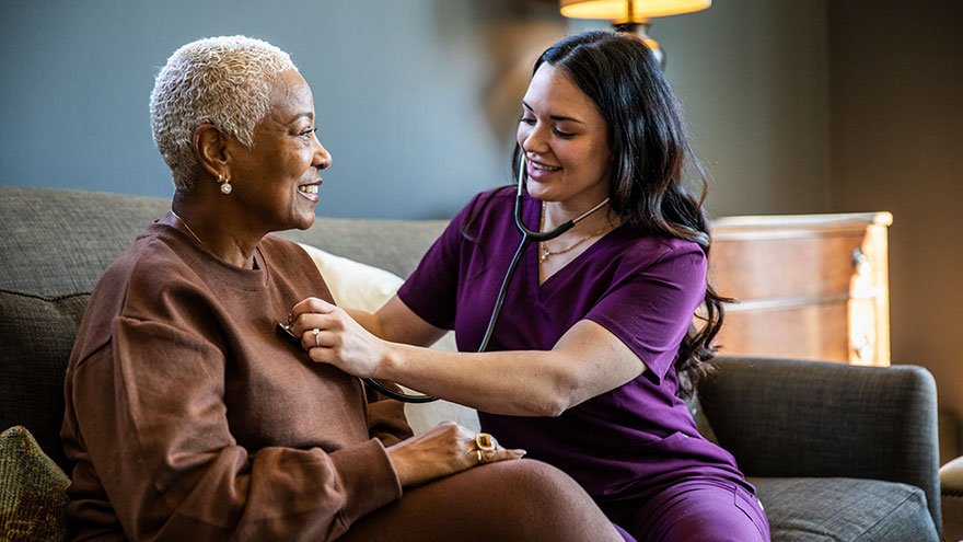 Nurse checking senior woman's vital signs in her home