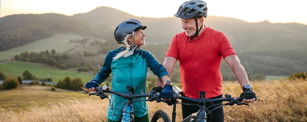 Portrait of beautiful senior couple on bike ride in autumn nature, looking at each other