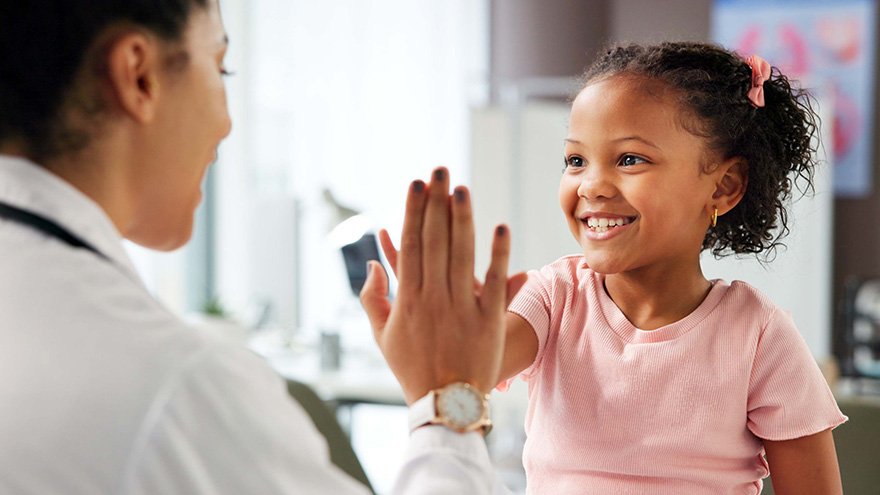 Provider and little patient high-fiving during appointment
