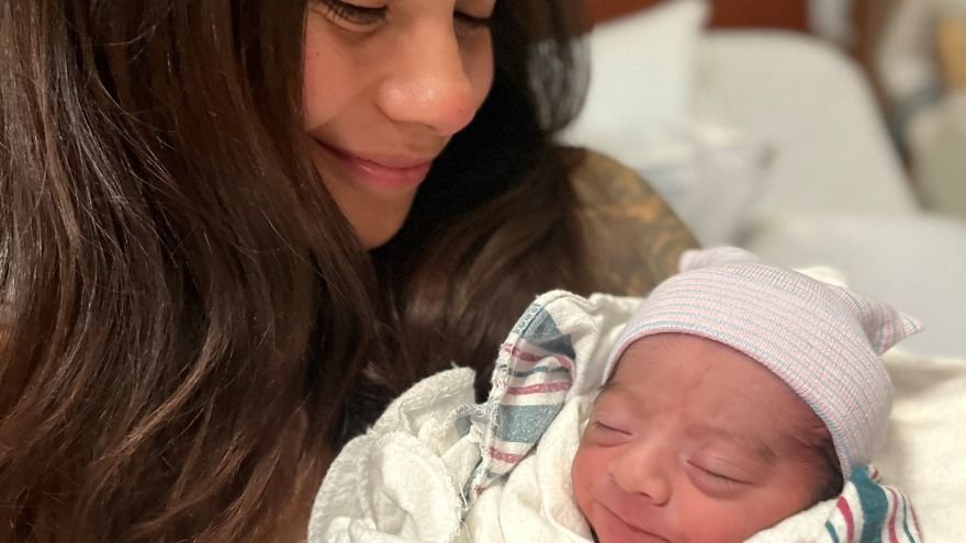 A mother smiling down at her happy newborn on New Year's Day.