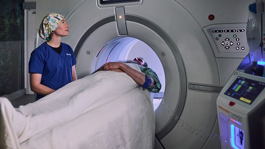 Provider standing with patient getting MRI