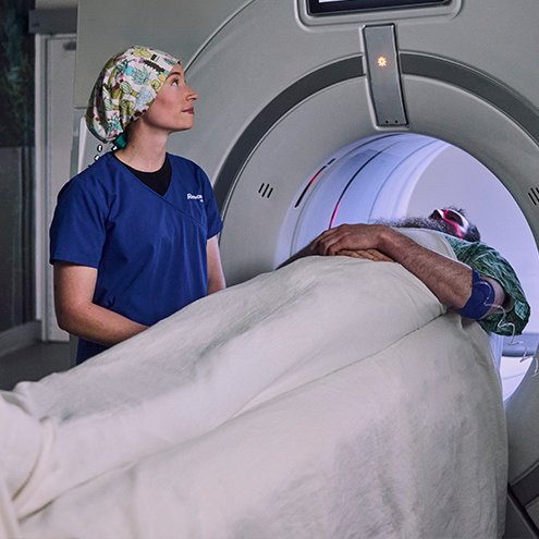 Provider standing with patient getting MRI