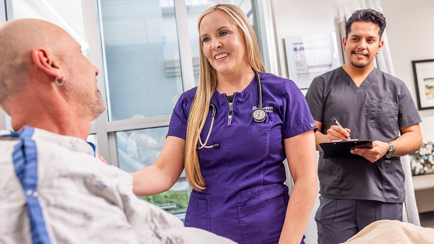 a nurse is talking to a patient in a hospital bed .
