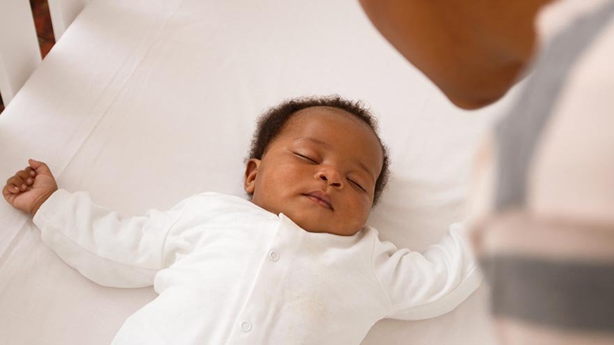Baby sleeping in a crib on their back