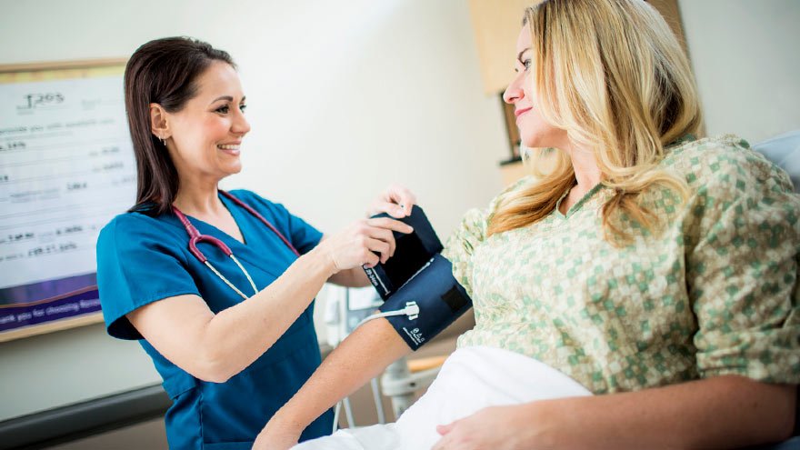 Nurse taking a woman's blood presure