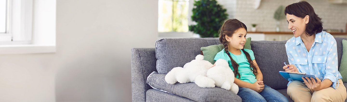 Child and therapist sitting on couch in conversation