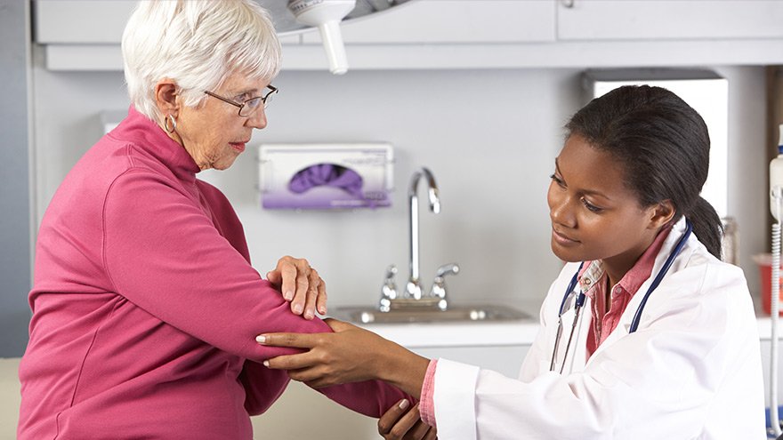 Doctor Examining Female Patient With Elbow Pain