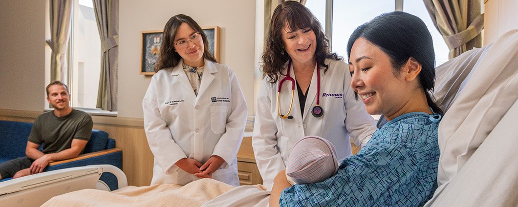 Renown and UNR Providers supporting new mom holding baby while father looks on
