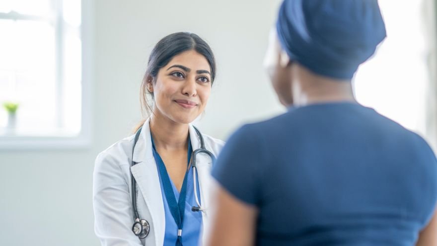A doctor sits listening to patient