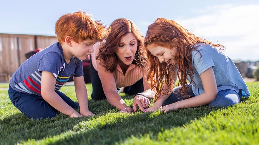 Mother with children playing in grass