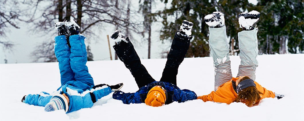 Kids outdoors in snow making snow angels
