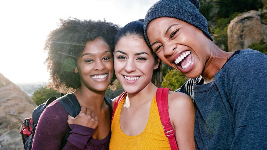 Three smiling women on a hike