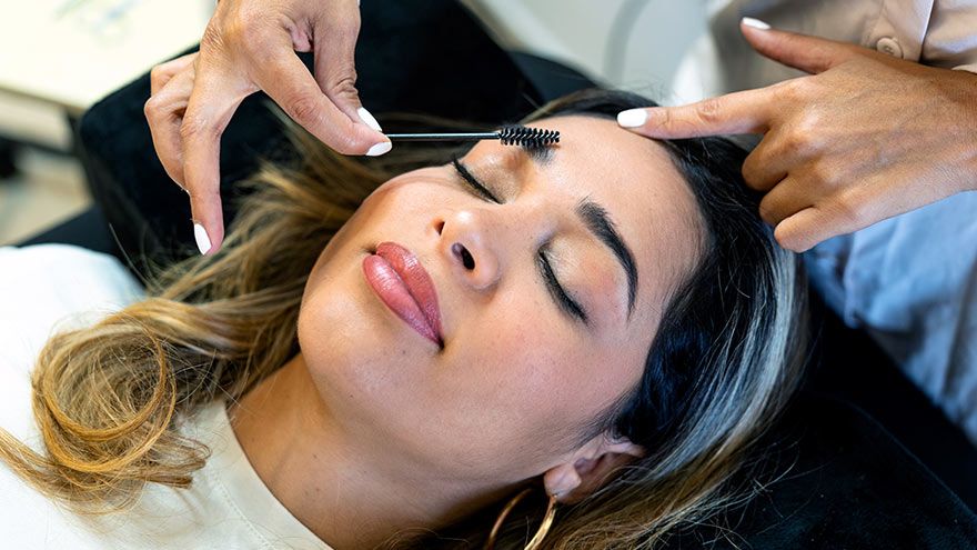 Latin woman receives aesthetic treatment on her eyebrows